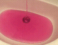 Detalhe da água completamente rosa caindo numa pia.